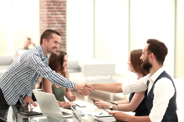 istock smiling business partners shaking hands over the Desk. 1188422550