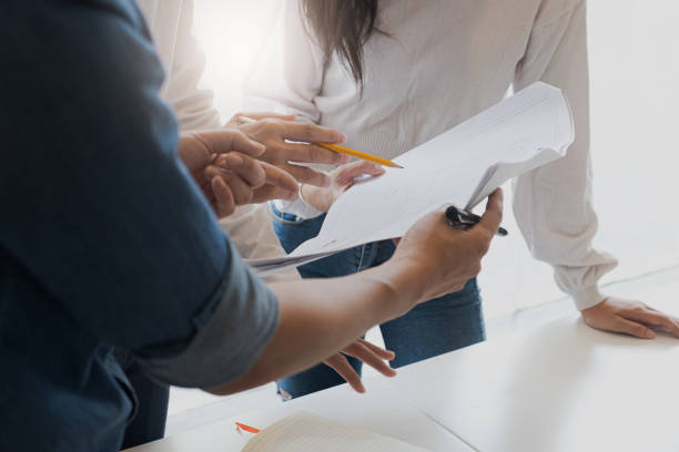 istock business people group on meeting and presentation in bright modern office with construction engineer architect and worker looking building model and blueprint plans 1188423564