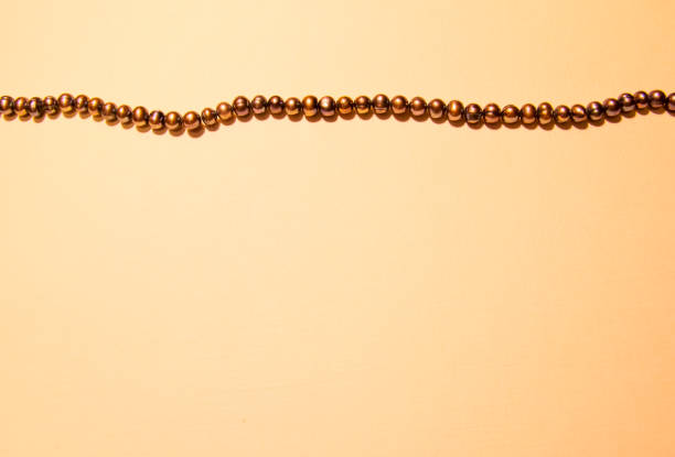 istock Background from textured paper and a string of black pearls 1188425116