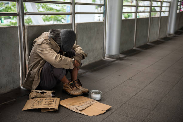 Sad Homeless old man in city Sad Homeless old man or beggar head down and sit on city walk. Poverty with depression feeling in winter. Social issue concept. homelessness photos stock pictures, royalty-free photos & images