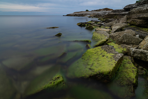 Stone wall on the Baltic sea in the summer. Osmussaar coast, island in Estonia, Europe.