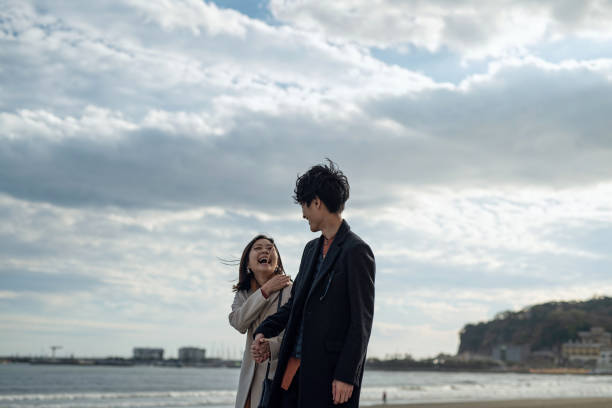 Couple walking at beach Couple dating at beach in Autumn shonan photos stock pictures, royalty-free photos & images