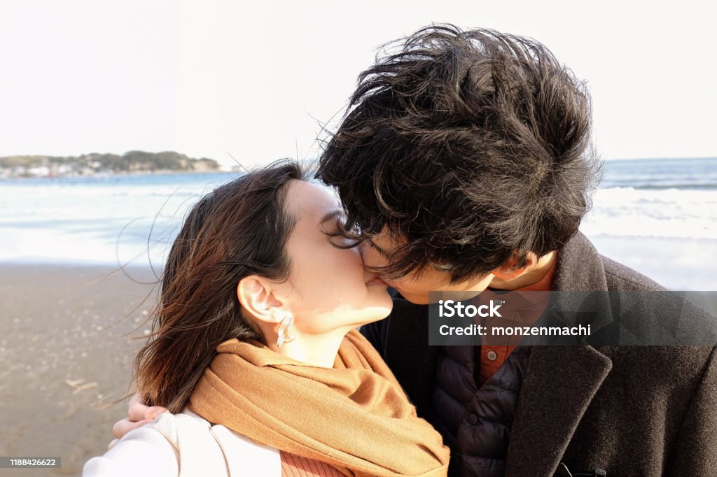 Closeup of young couple kissing at beach Closeup of couple kissing at beach Kissing Stock Photo