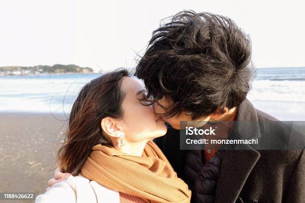 Closeup Of Young Couple Kissing At Beach Stock Photo - Download Image Now - Kissing, Japanese Ethnicity, Couple - Relationship