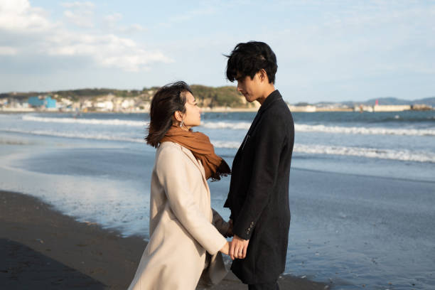 Couple looking at each other at beach Couple dating at beach in Autumn shonan photos stock pictures, royalty-free photos & images