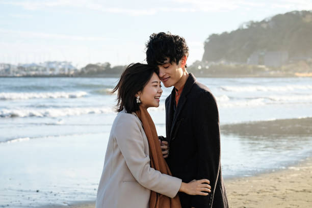Couple looking at each other at beach Couple dating at beach in Autumn fujisawa kanagawa photos stock pictures, royalty-free photos & images