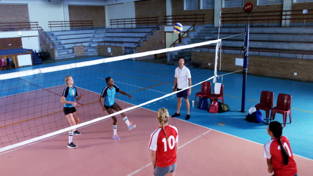 Female players playing volleyball in the court 4k