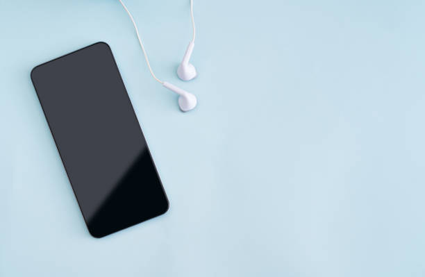 istock Smart phone with Headphones on blue background 1188429280