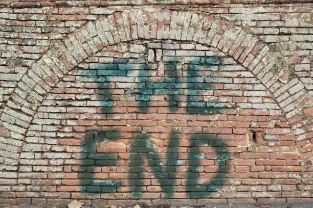 "The end" is spray-painted onto a bricked up archway in a wall. *** The text was digitally added and a release is provided ***