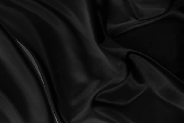istock Black gray satin dark fabric texture luxurious shiny that is abstract silk cloth background with patterns soft waves blur beautiful. 1188429492