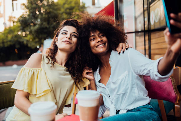 Two girlfriends taking a selfie at the cafe