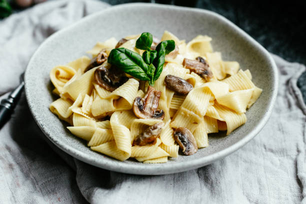 istock Plate with spaghetti with mushrooms in a creamy sauce on the table 1188431288