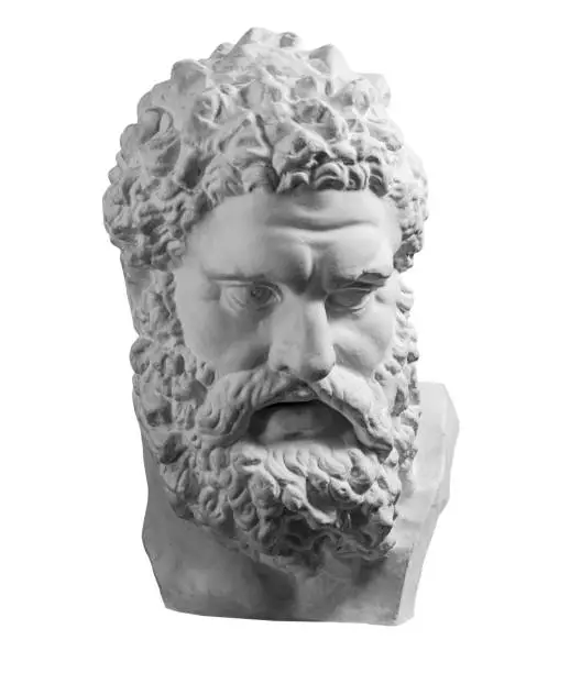 Photo of Gypsum copy of ancient statue Heracles head isolated on white background. Plaster sculpture man face.