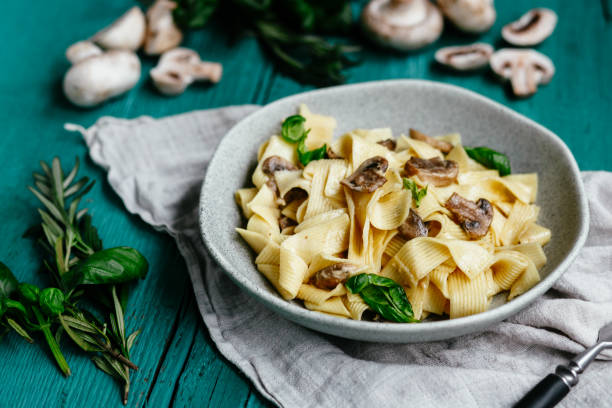 istock Plate with spaghetti with mushrooms in a creamy sauce on the table 1188434418