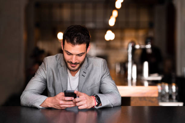 istock Young businessman using his smart phone at a local restaurant 1188434440