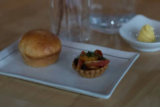 amuse bouche of fruit tart and  bread and butter and bottle of water