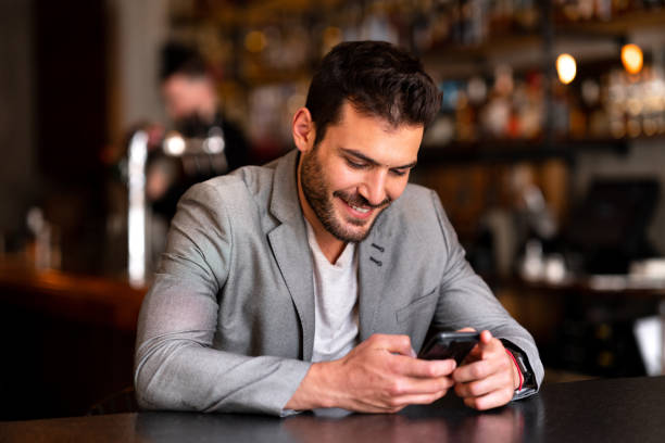 istock Young businessman using his smart phone at a local restaurant 1188434474