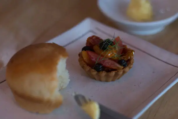 amuse bouche of fruit tart and  bread and butter and bottle of water