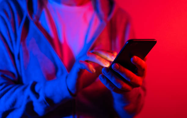 istock Male hand with smartphone. Finger typing on screen. Neon light 1188434928