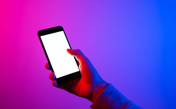 istock Male hands with smartphone. Empty white screen. Mock-up. Neon light 1188434948