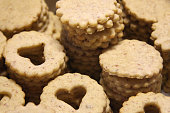 Stacked shortbread biscuits for linzer biscuits lie on white paper