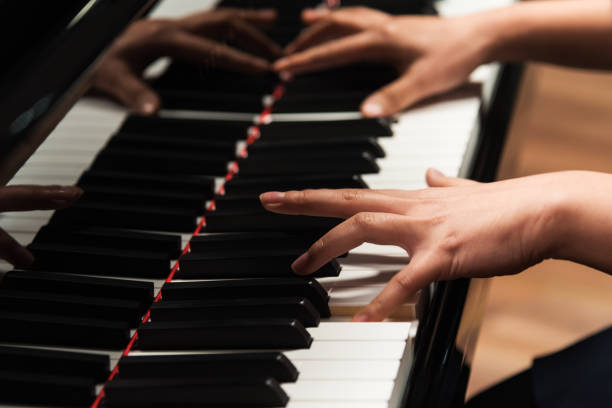 istock Closeup young woman hands playing piano 1188435490