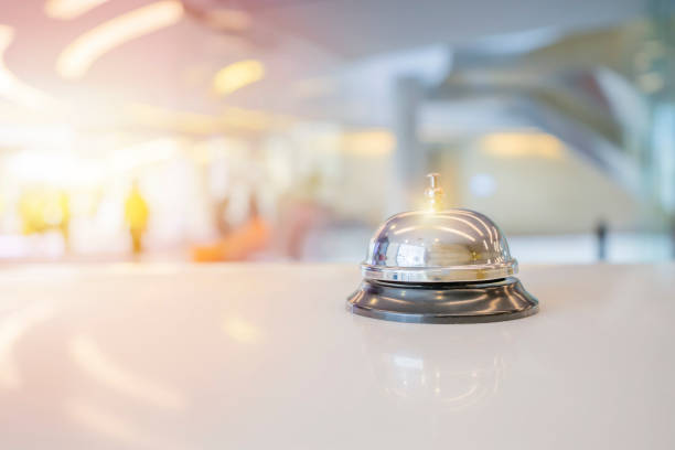 колокол обслуживания отеля на белом стекле стола. - service bell bell customer service стоковые фото и изображения