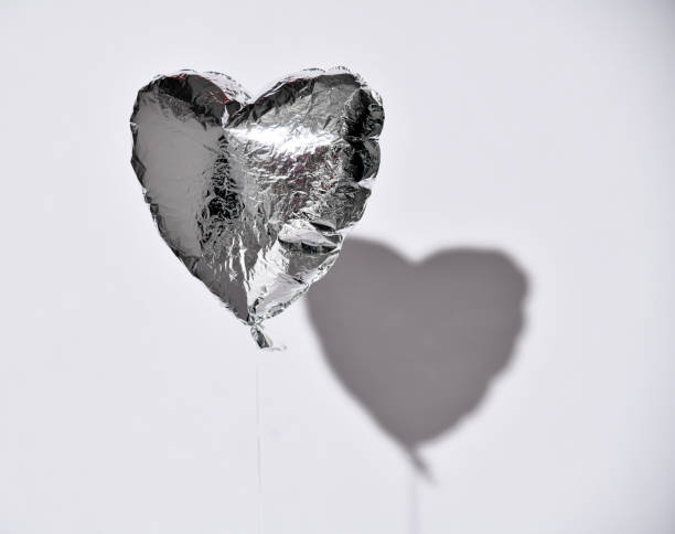 istock Party is over deflated silver heart balloon object  on white gray background with shadow 1188437935