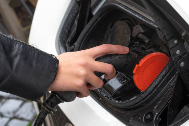 istock Female hand inserting charger plug into electric car. 1188437982