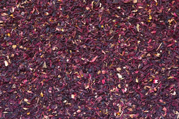 Photo of Leaves of dry cut hibiscus tea as background