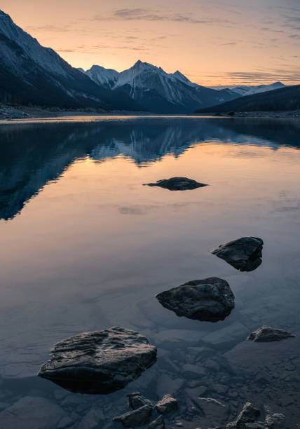 lever de soleil sur la montagne rocheuse avec des roches dans le lac de médecine dans le parc national de jasper - canada alberta mountain mountain range photos et images de collection