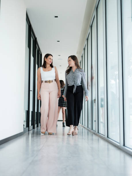 istock Two businesswomen walking together on corridor 1188439985
