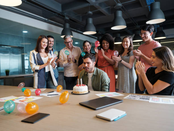 istock Latin office people standing while coworker blows birthday candles 1188440079
