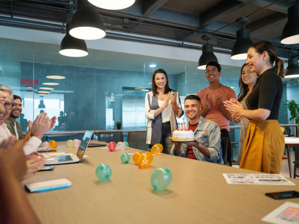 istock Young latin man celebrating in coworking space with birtday cake 1188440096