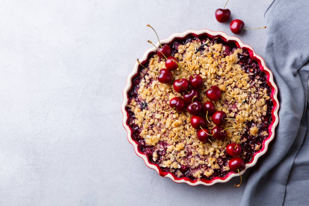 istock Cherry, red berry crumble in baking dish. Grey background. Top view. Copy space. 1188444291