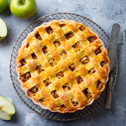 Apple pie on a cooling rack. Grey background. Close up. Top view
