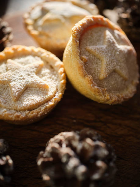 istock Three Mince Pies against dark wood with snow covered pine cones. 1188446437