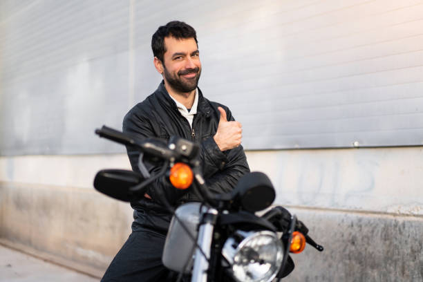 istock Young man on a motorbike with thumb up 1188448978