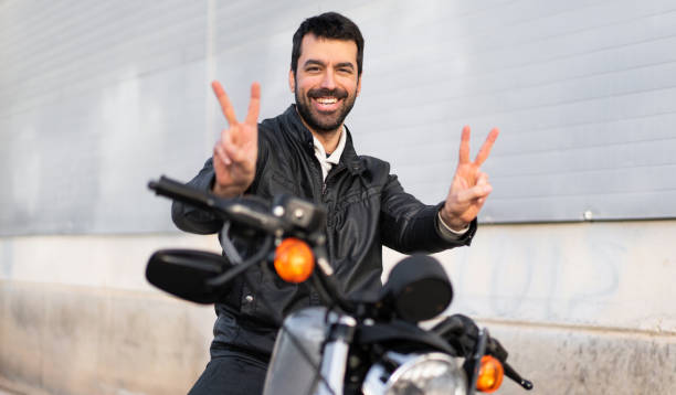 istock Young man on a motorbike making victory gesture 1188449079