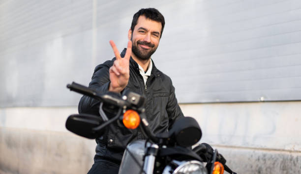 istock Young man on a motorbike making victory gesture 1188449214