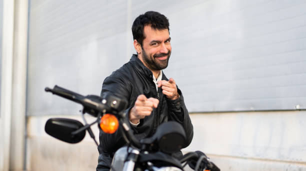 istock Young man on a motorbike pointing to the front 1188449472
