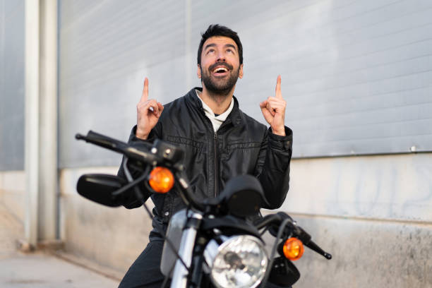 istock Young man on a motorbike pointing up 1188449574
