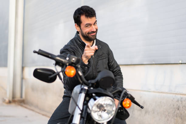 istock Young man on a motorbike pointing to the front 1188449640