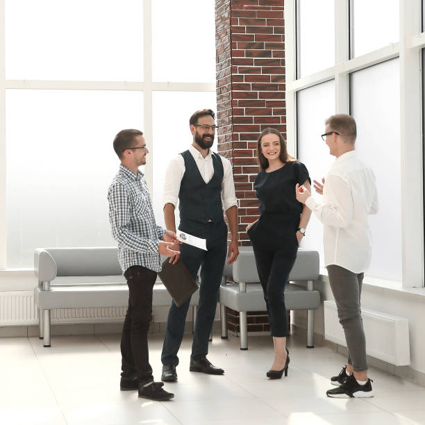 istock employees discuss new ideas, standing in the office lobby. 1188450547