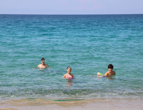 three young brothers on the sea in summer