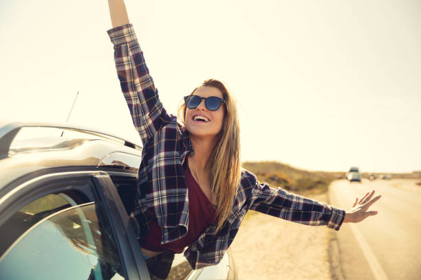 istock happy girl looking out the car window 1188451141