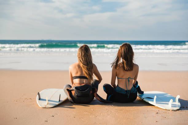 istock Surfer girls at the beach 1188451163