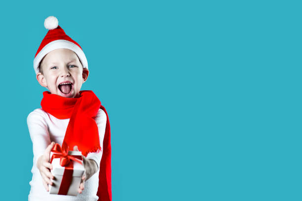 istock little cheerful Santa gives a gift on mint background 1188451379