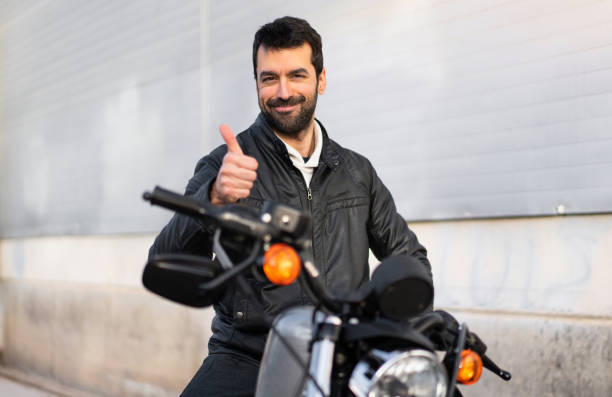 istock Young man on a motorbike with thumb up 1188451394