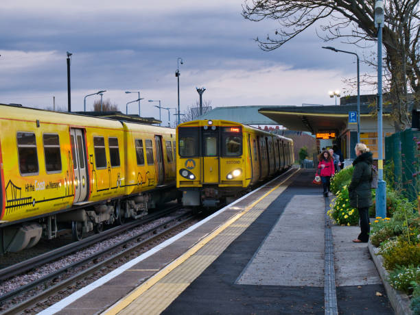 um trem chega enquanto um outro trem espera na estação de hoylake na rede de transporte elétrica do trilho de merseyrail, uma rede regional do viajante de bilhete mensal com liverpool como seu cubo - british rail - fotografias e filmes do acervo